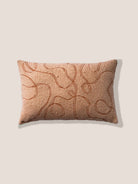 Decorative pillow with embroidered pattern on a beige background