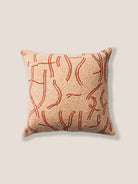 Decorative pillow with abstract red pattern on a beige background