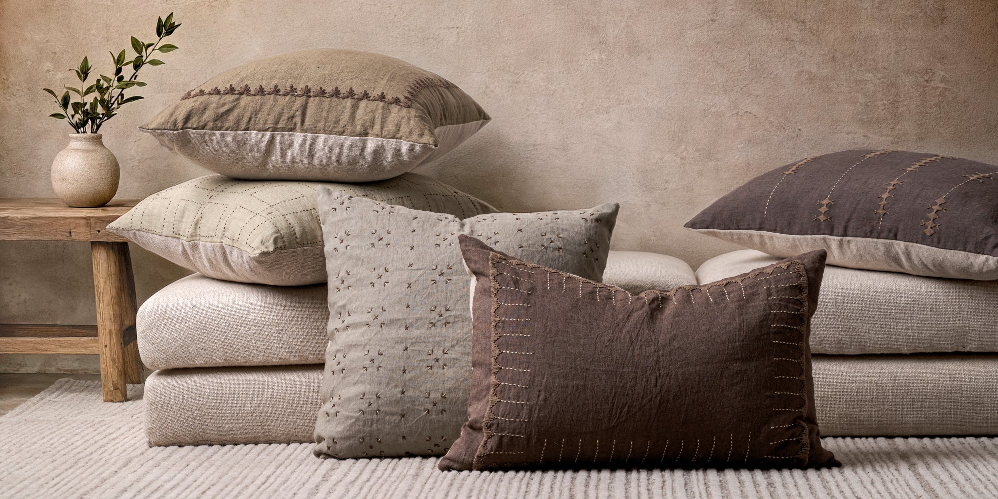 Stack of textured pillows on a sofa with a neutral color palette.